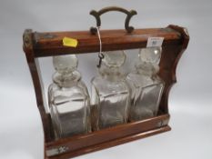 A VINTAGE THREE BOTTLE TANTALUS WITH KEY