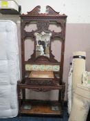 AN EDWARDIAN CARVED MIRRORED HALLSTAND WITH TILE BACK