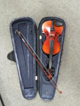 A SMALL STUDENT TYPE VIOLIN AND BOW IN A FITTED STAG HARDCASE