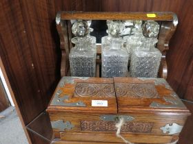 AN OAK CASED THREE BOTTLED TANTALUS WITH MULTI SECTION COMPARTMENT