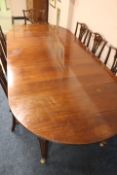 AN ANTIQUE MAHOGANY WIND-OUT DINING TABLE AND THREE LEAVES, the table raised on squared tapered