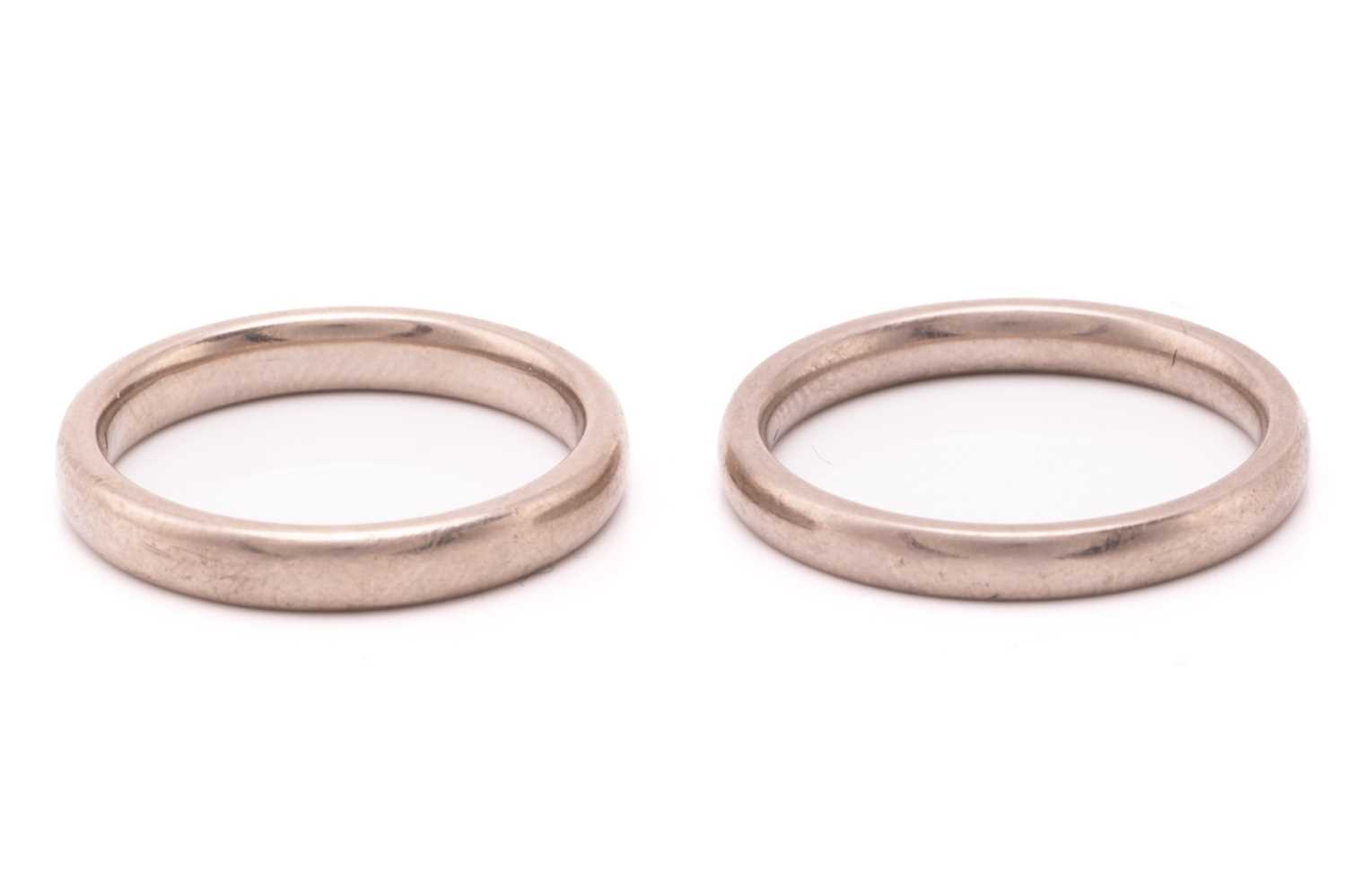 Two wedding bands in 18ct white gold; the first one is constructed with a plain court-profile