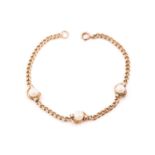 A 9ct gold and pearl curb pattern bracelet, set with three approximately 6mm pearls each flanked