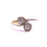 A diamond Toi et Moi crossover ring, scintillating with two flowerhead clusters composed of two