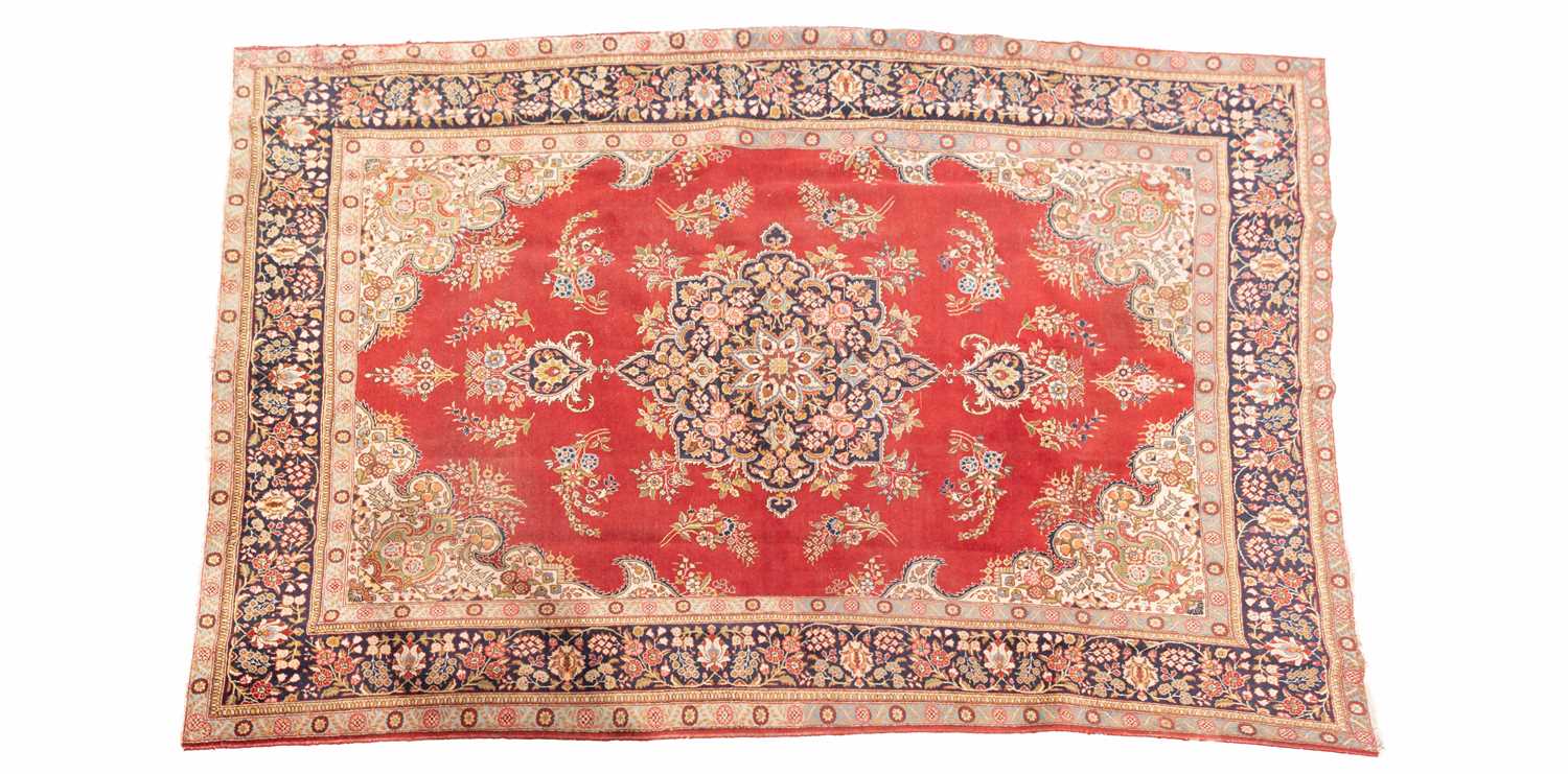 A red ground Tabriz carpet, 20th century, with a central polylobate "book-cover" design within