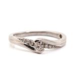 A diamond set cross-over ring, featuring a central round brilliant-cut diamond measuring 3.