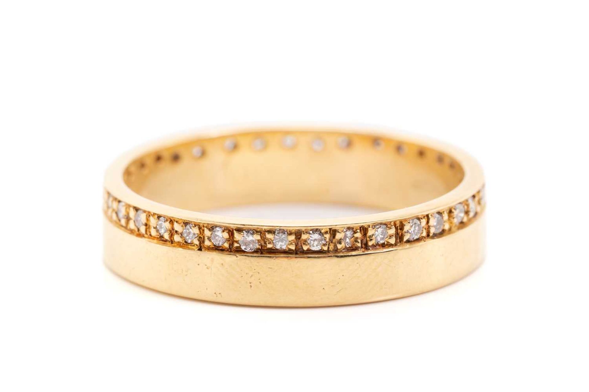 An 18ct yellow gold and diamond wedding band, comprising a flat band pavé-set with a continuous