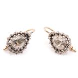 A pair of 19th-century diamond earrings, each encapsulating a pear-shaped rose-cut diamond in a
