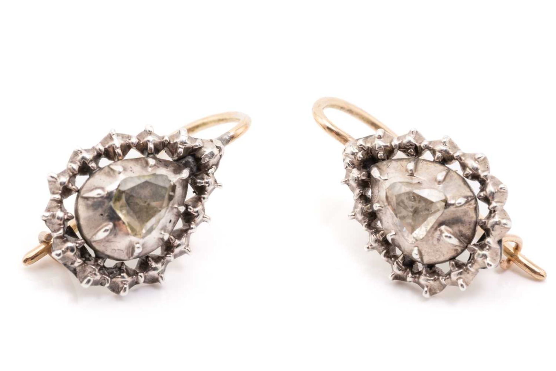 A pair of 19th-century diamond earrings, each encapsulating a pear-shaped rose-cut diamond in a