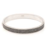 Theo Fennell. An 18ct white gold hinged bangle set with black and white diamonds, half of the band