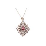 A ruby and diamond pendant on chain, of scrolled foliate design, centred with a cushion-cut ruby