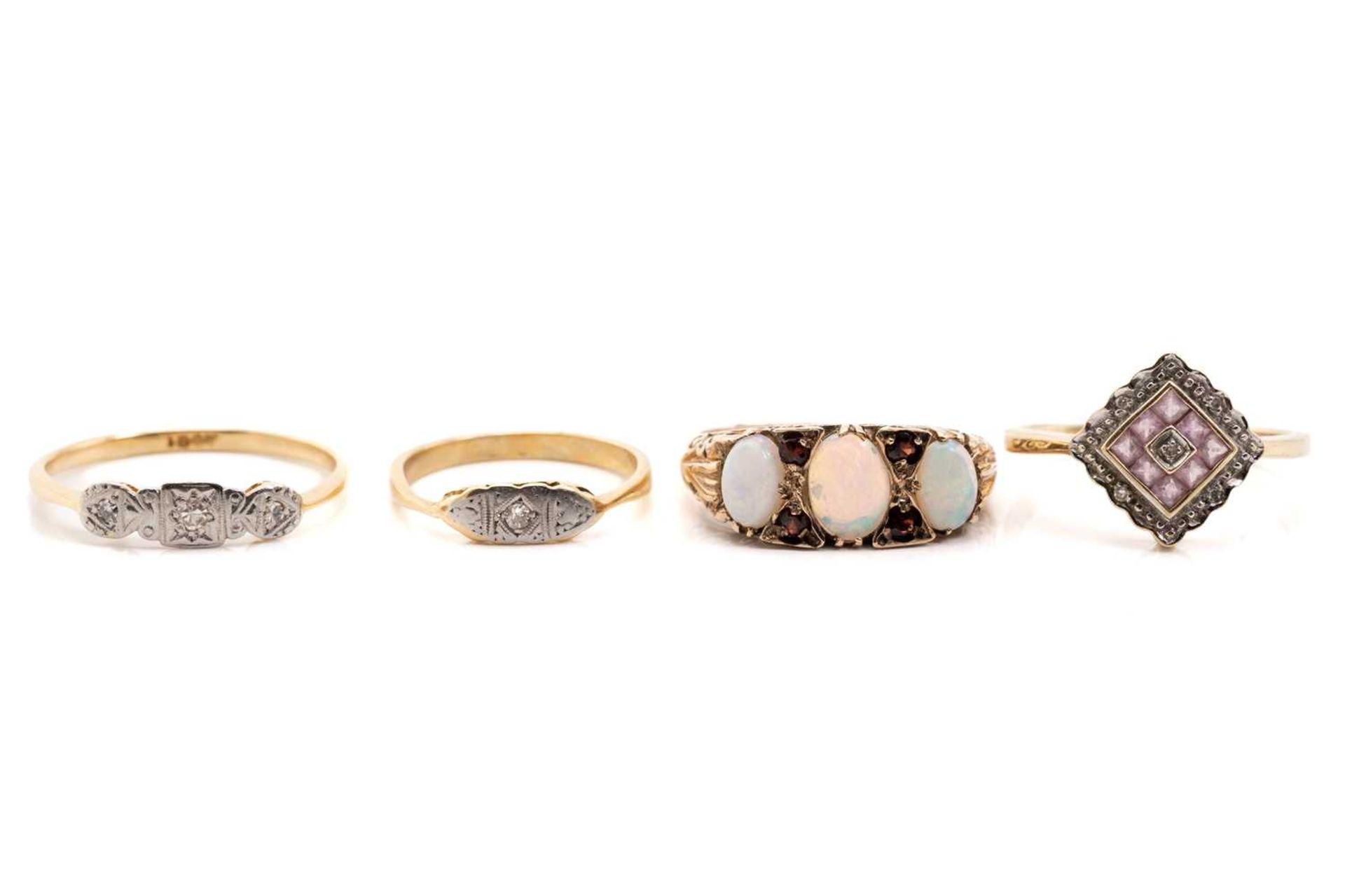 Four gem-set dress rings, including an Edwardian three stone diamond ring, illusion set in