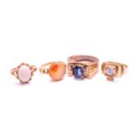 Four gem-set rings, including an Aqeeq ring with a round carnelian in coronet setting, engraved with