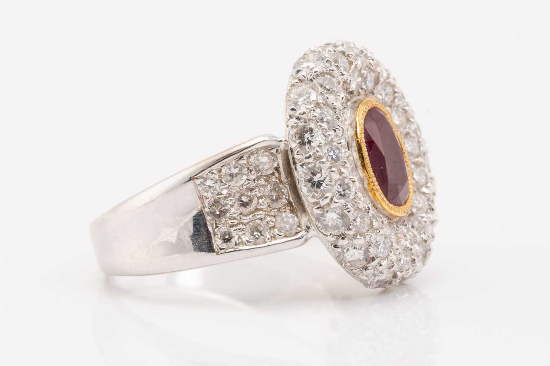 A synthetic ruby and diamond cluster style ring, featuring a rub over set oval cut synthetic ruby - Image 2 of 5