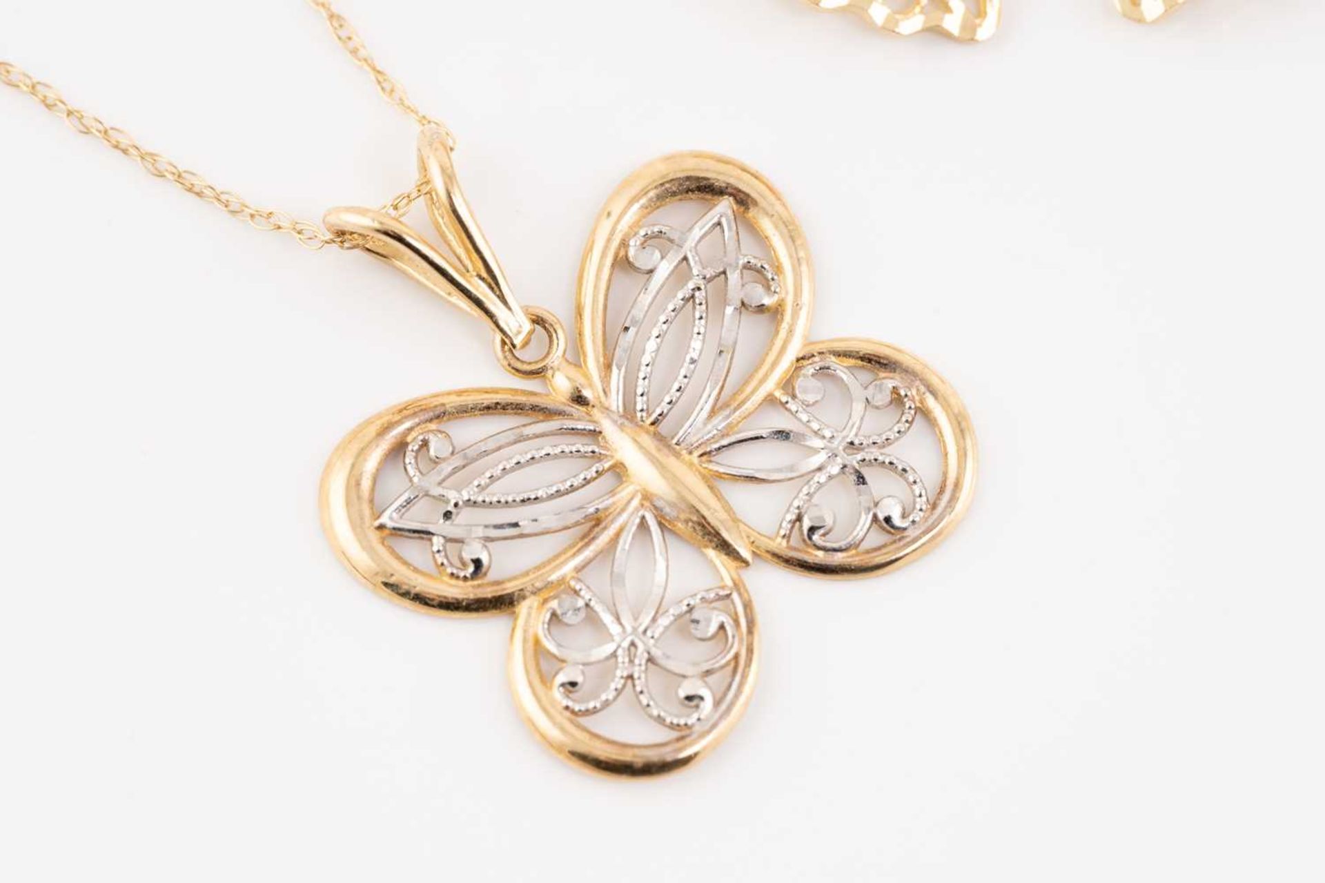 A collection of four pieced-out pendants on chains, including a 10ct gold pierced butterfly - Image 3 of 6