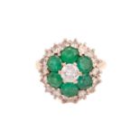 An emerald and diamond cluster ring, centred with a brilliant-cut diamond and five circular-cut