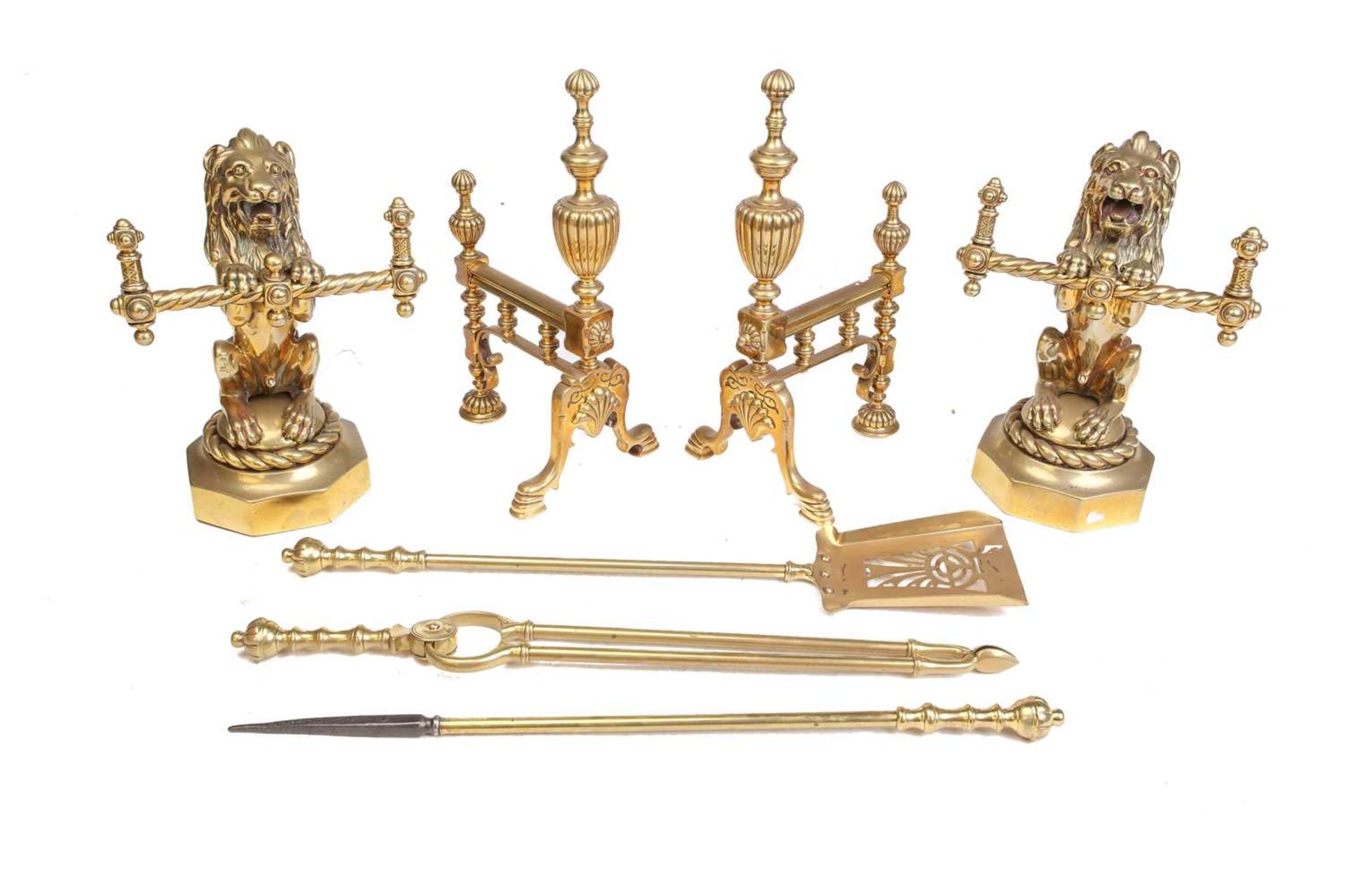 A pair of Victorian cast and gilt brass heraldic sejant erect lion firedogs, each holding a