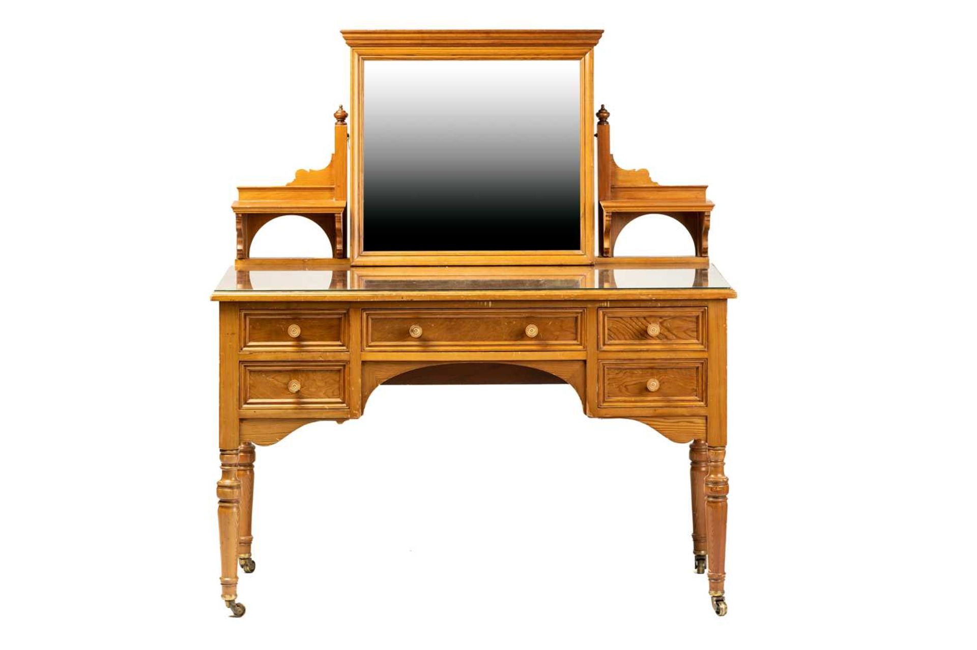 An Edwardian pine? dressing table by Howard & Sons, the swing mirror on shelved supports above a