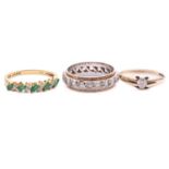Three gem-set rings in gold; to include an 18ct gold ring set with alternating emeralds and
