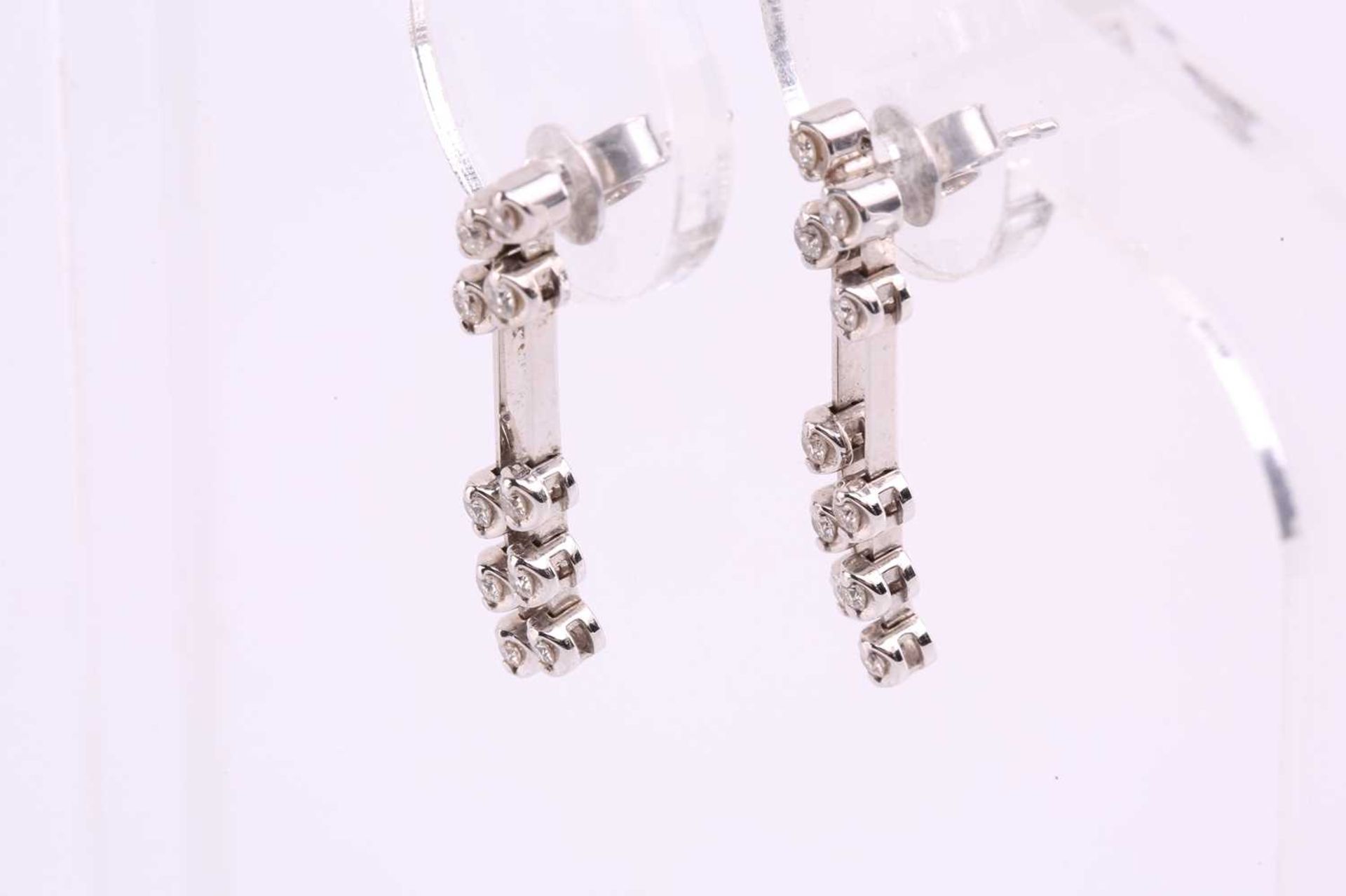 A pair of diamond drop earrings in 18ct white gold, each containing two lines of articulated - Image 3 of 3