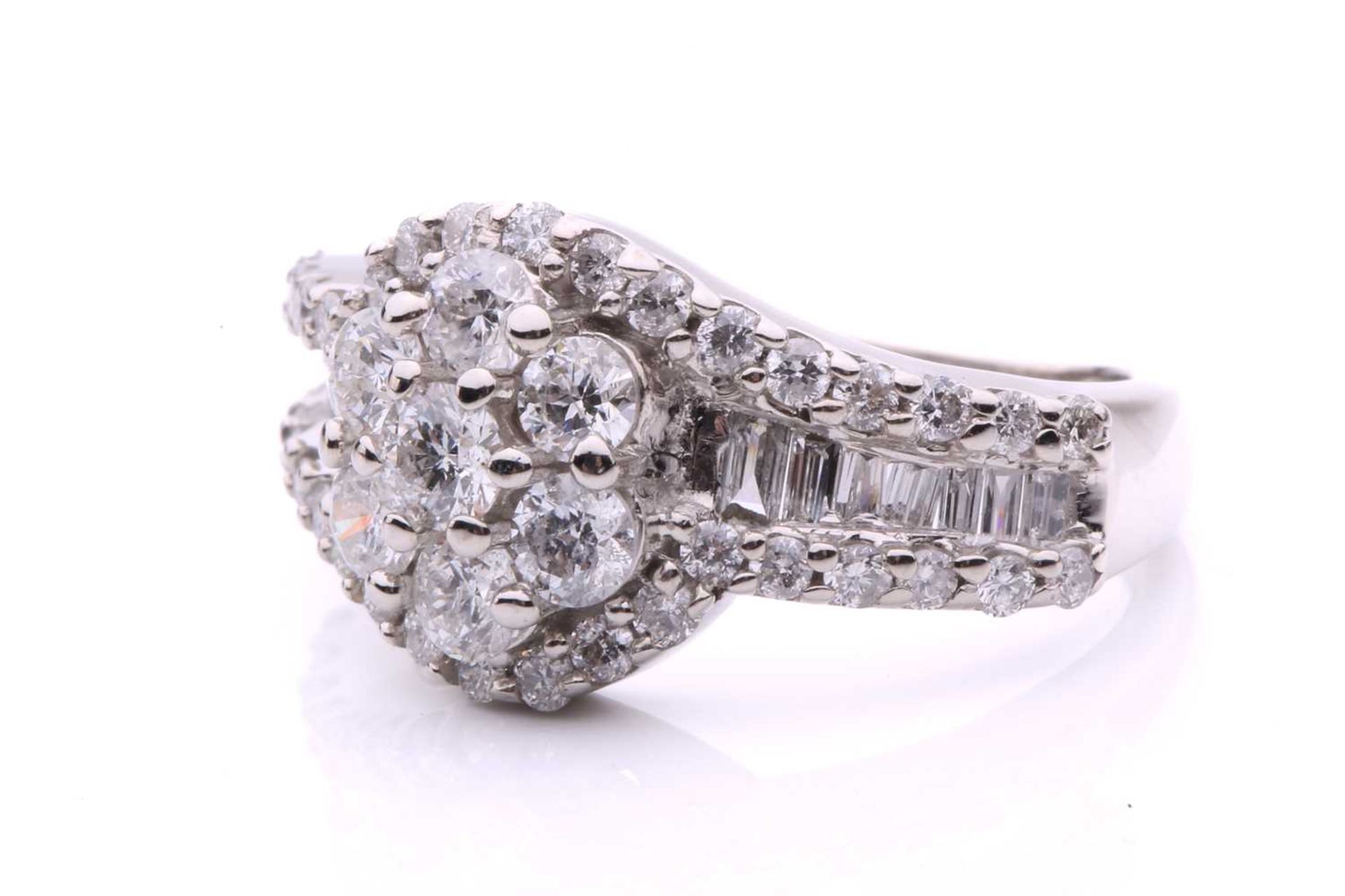 A diamond cluster crossover ring, with seven claw set round brilliant cut diamonds in a daisy - Image 2 of 6