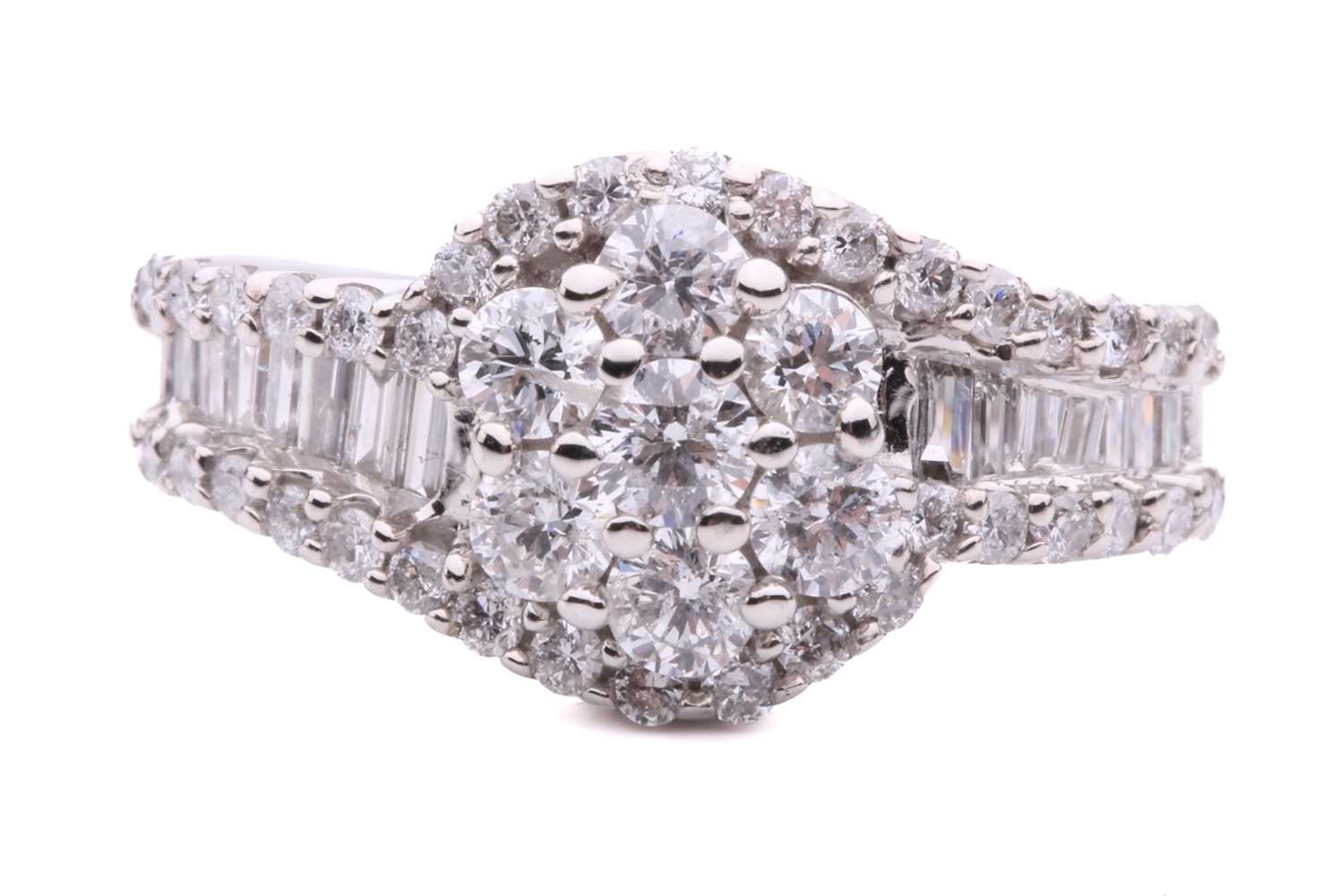 A diamond cluster crossover ring, with seven claw set round brilliant cut diamonds in a daisy