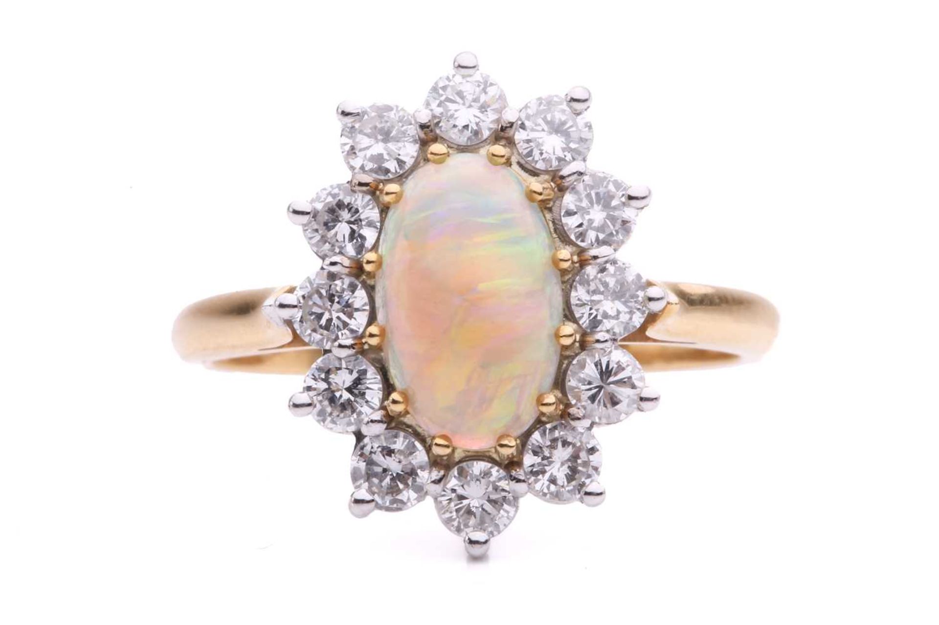 An opal and diamond entourage ring in 18ct gold, featuring an oval precious opal cabochon of 9.2 x