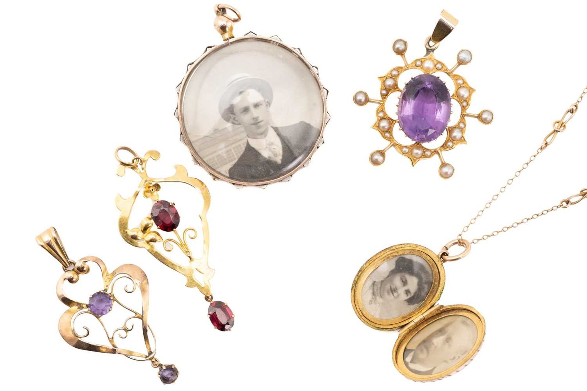 A collection of five pendants comprising an amethyst and seed pearl pendant, two gem and paste set