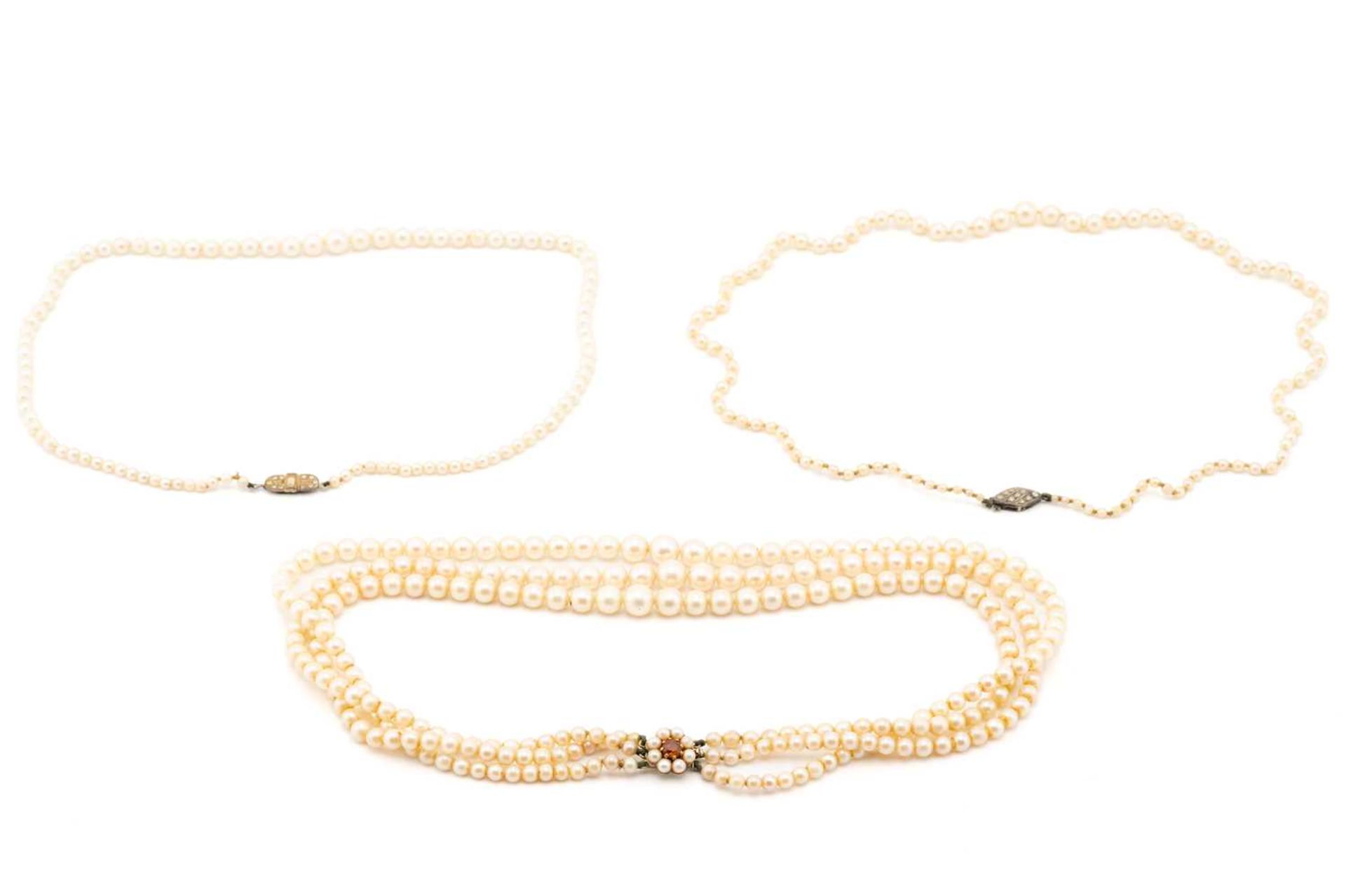 Three cultured pearl necklaces, comprising two single-strand graduated pearl necklaces, 53cm long