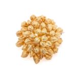An 18 carat gold flower head brooch; bombé shaped and composed of layers of textured petals.
