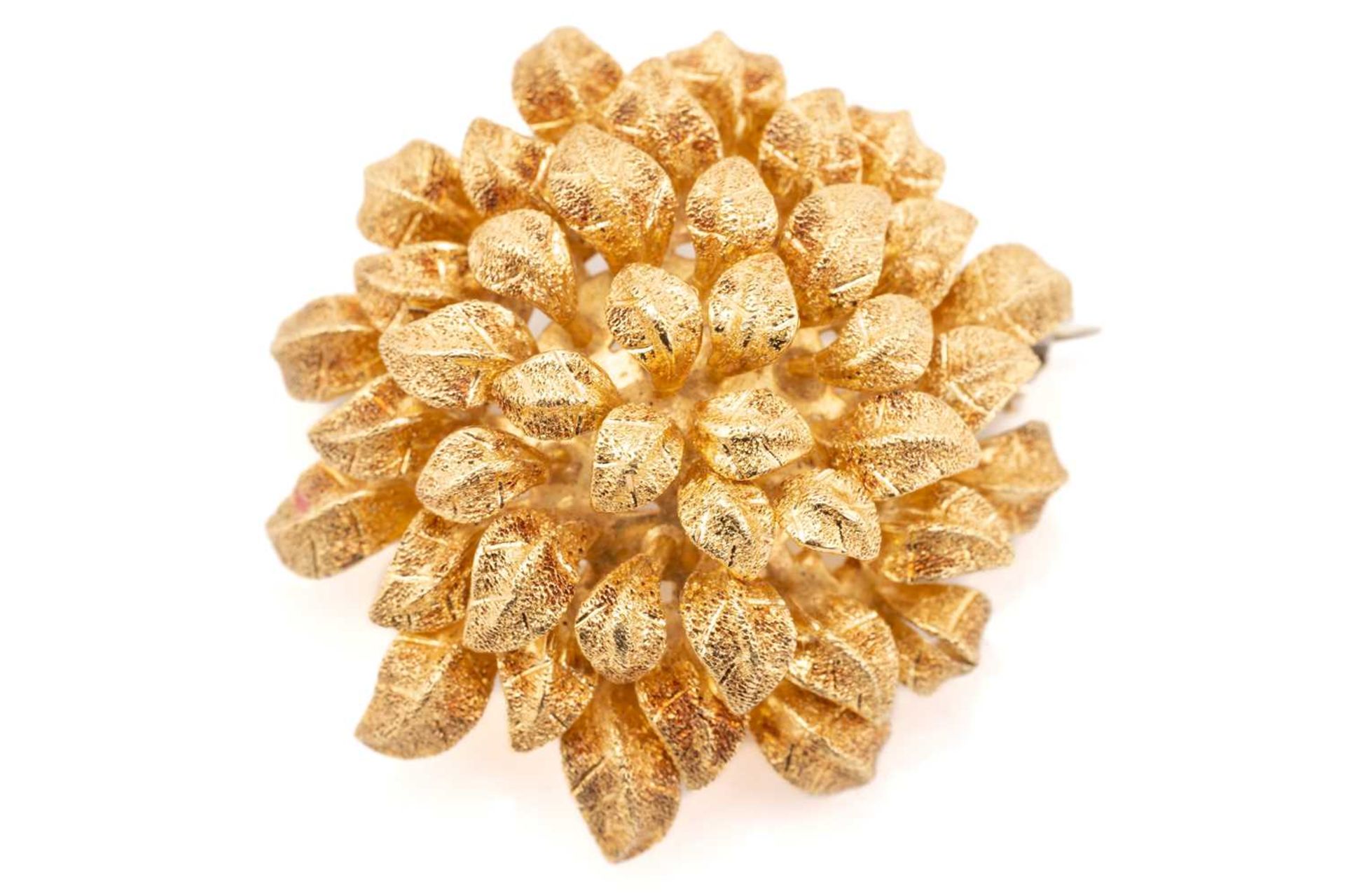 An 18 carat gold flower head brooch; bombé shaped and composed of layers of textured petals.