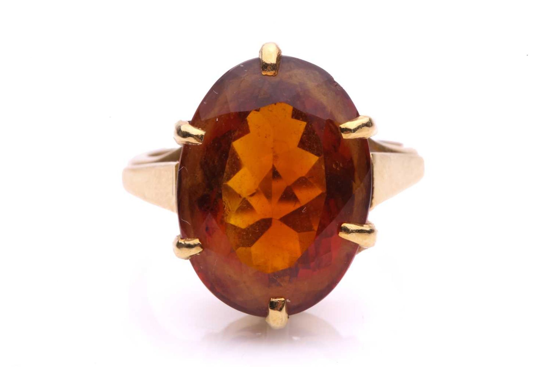 A large citrine cocktail ring, consisting of an oval-cut citrine with a brownish-orange body colour,