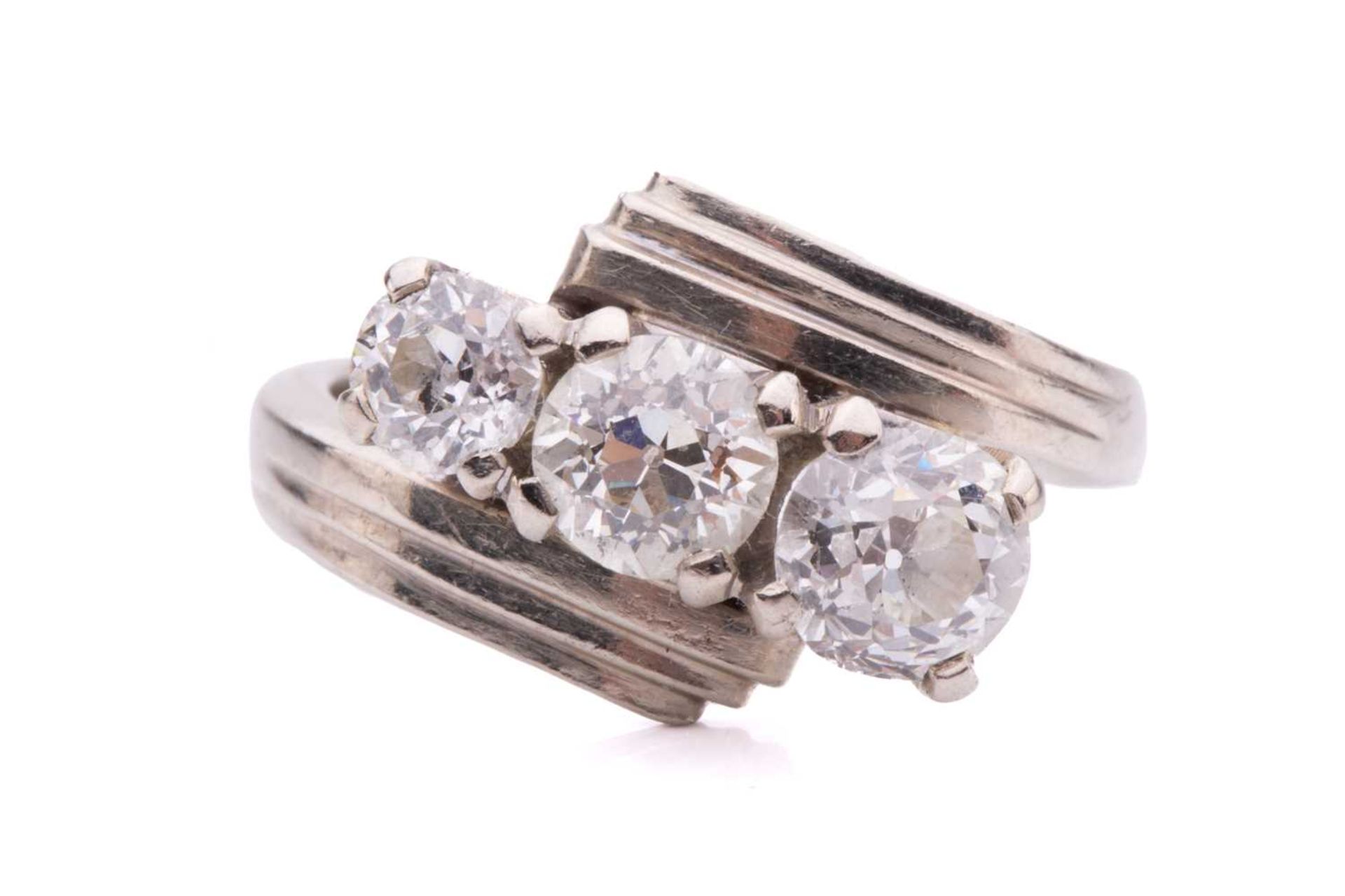 A three-stone old cut diamond ring, with three graduating round old cut diamonds measuring 5.5mm,