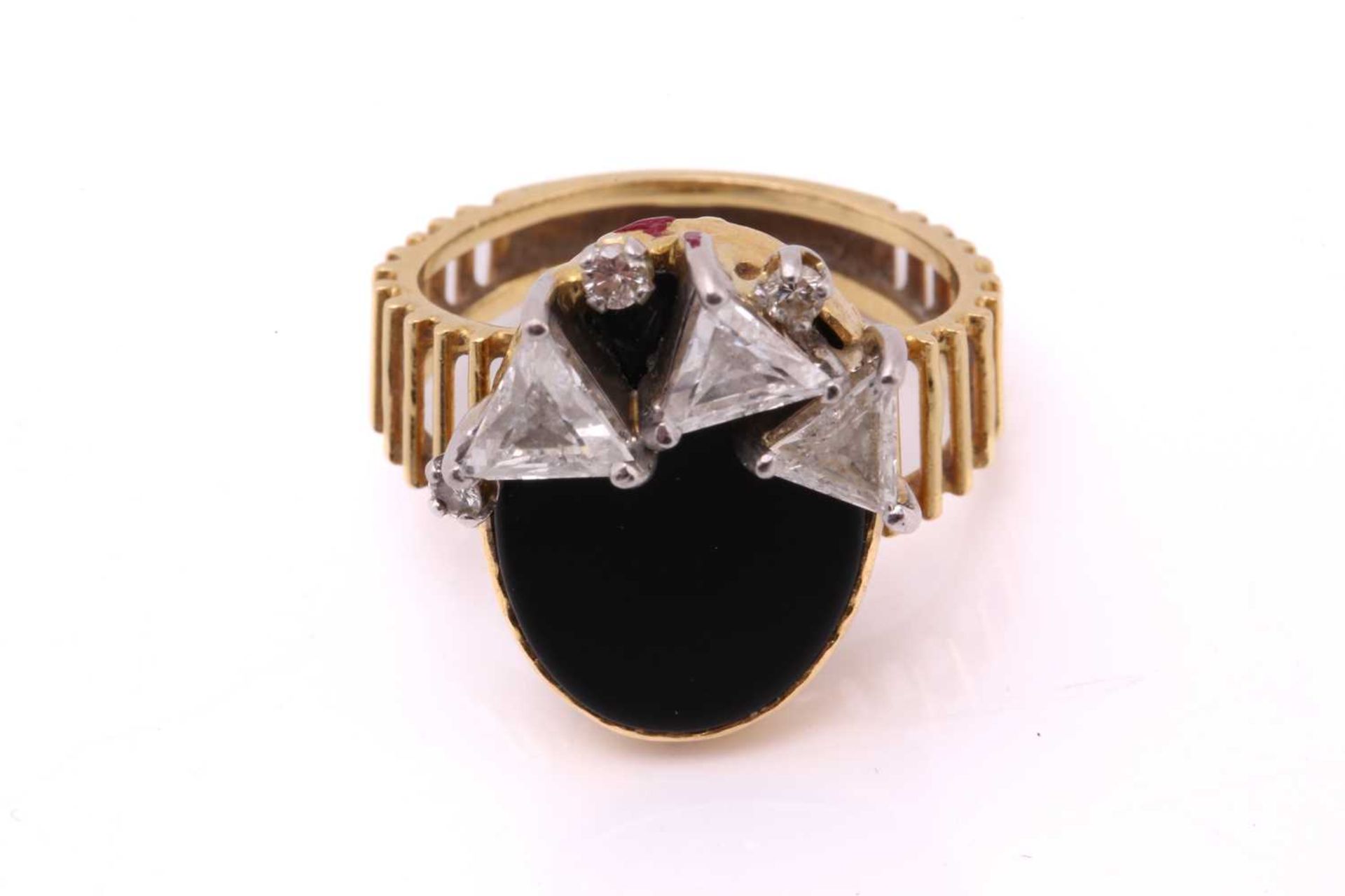 An 18ct gold Modernist ring set with onyx and diamonds, featuring three triangular step-cut diamonds