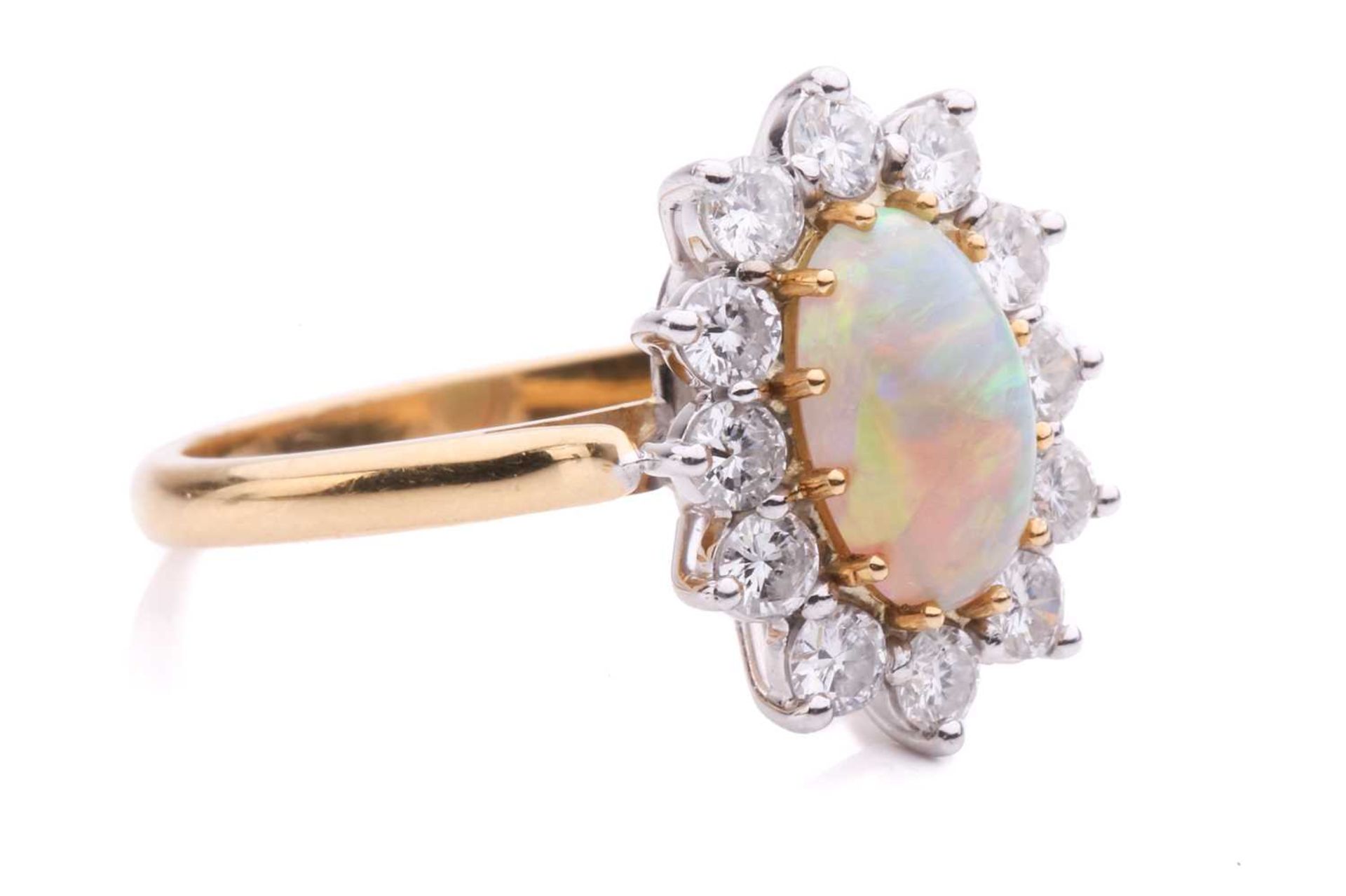 An opal and diamond entourage ring in 18ct gold, featuring an oval precious opal cabochon of 9.2 x - Image 4 of 5