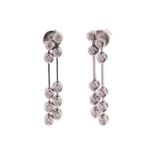 A pair of diamond drop earrings in 18ct white gold, each containing two lines of articulated