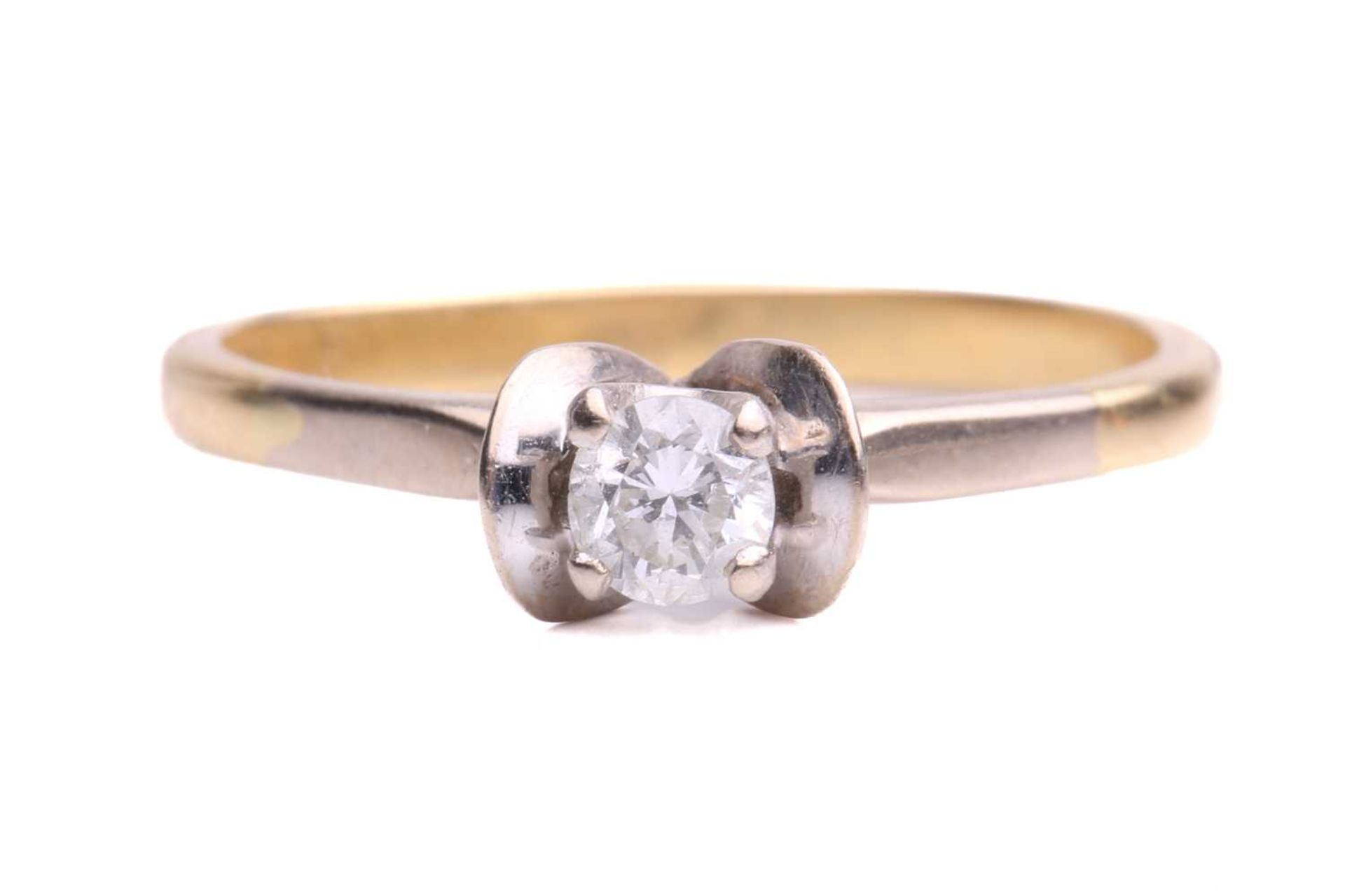 A single stone diamond ring; the round brilliant cut diamond in four claw mount between scalloped
