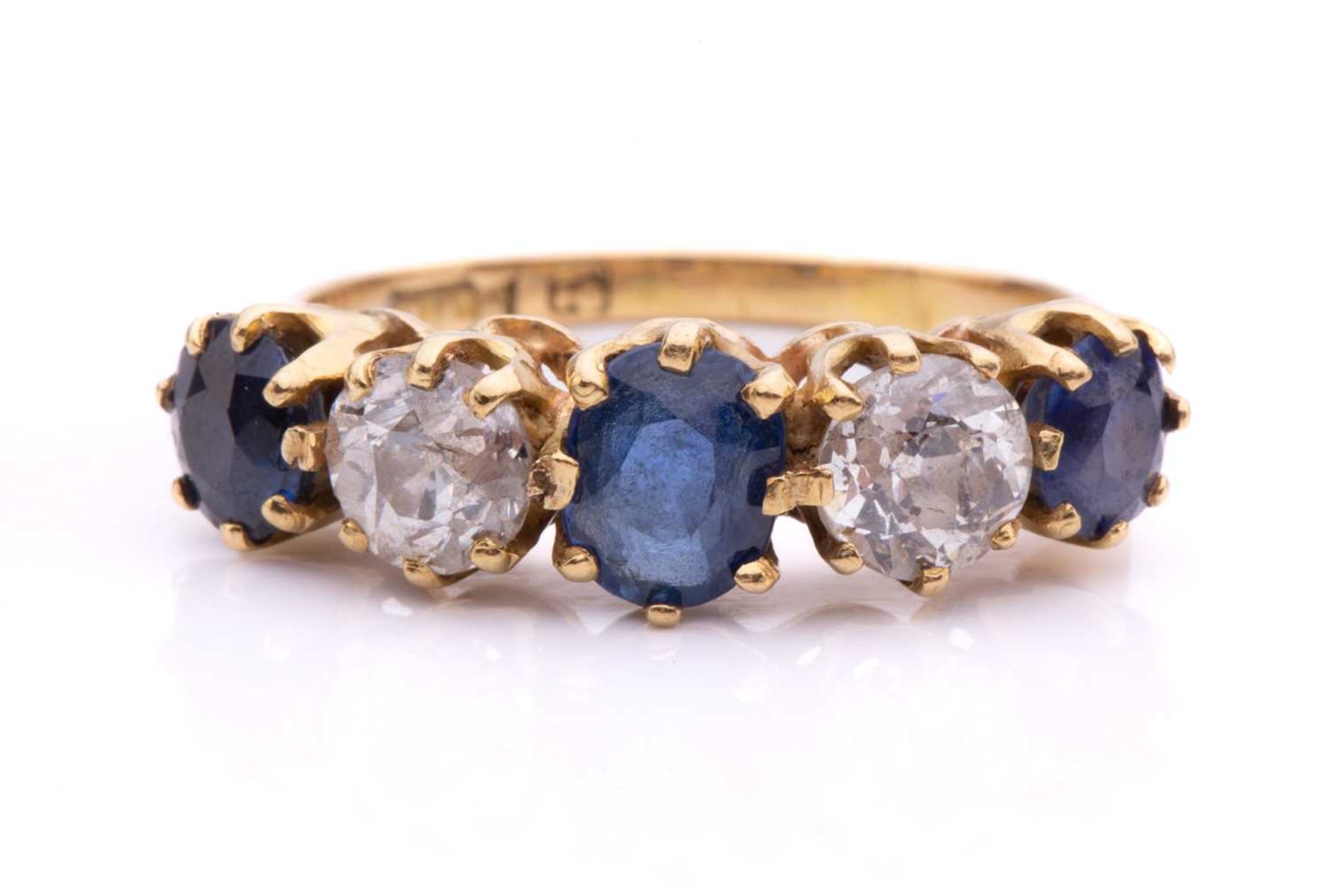 A five-stone diamond and sapphire half-hoop ring, with graduated faceted sapphires in coronet