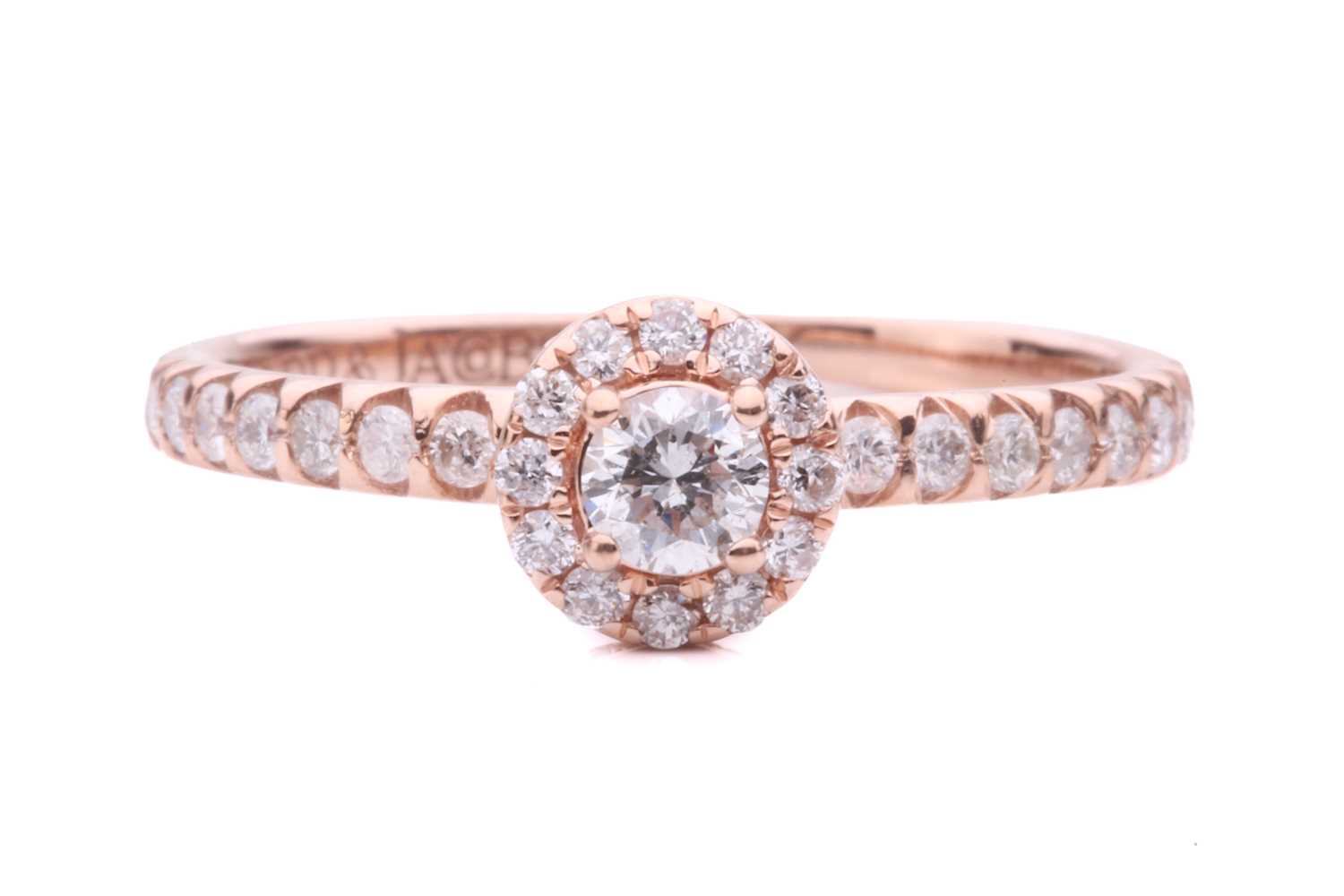 A diamond halo ring with diamond set shoulders, with a central round brilliant cut diamond measuring