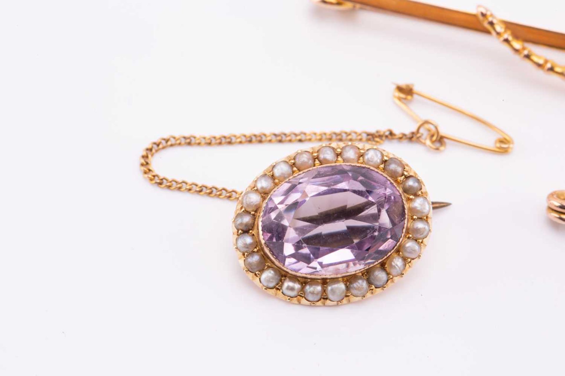 Three gem-set brooches with seed pearls; the first contains an oval-cut amethyst with pale purple - Image 3 of 7