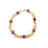 A seven stone amethyst bracelet, the circular cut stones set in claw mounts between textured
