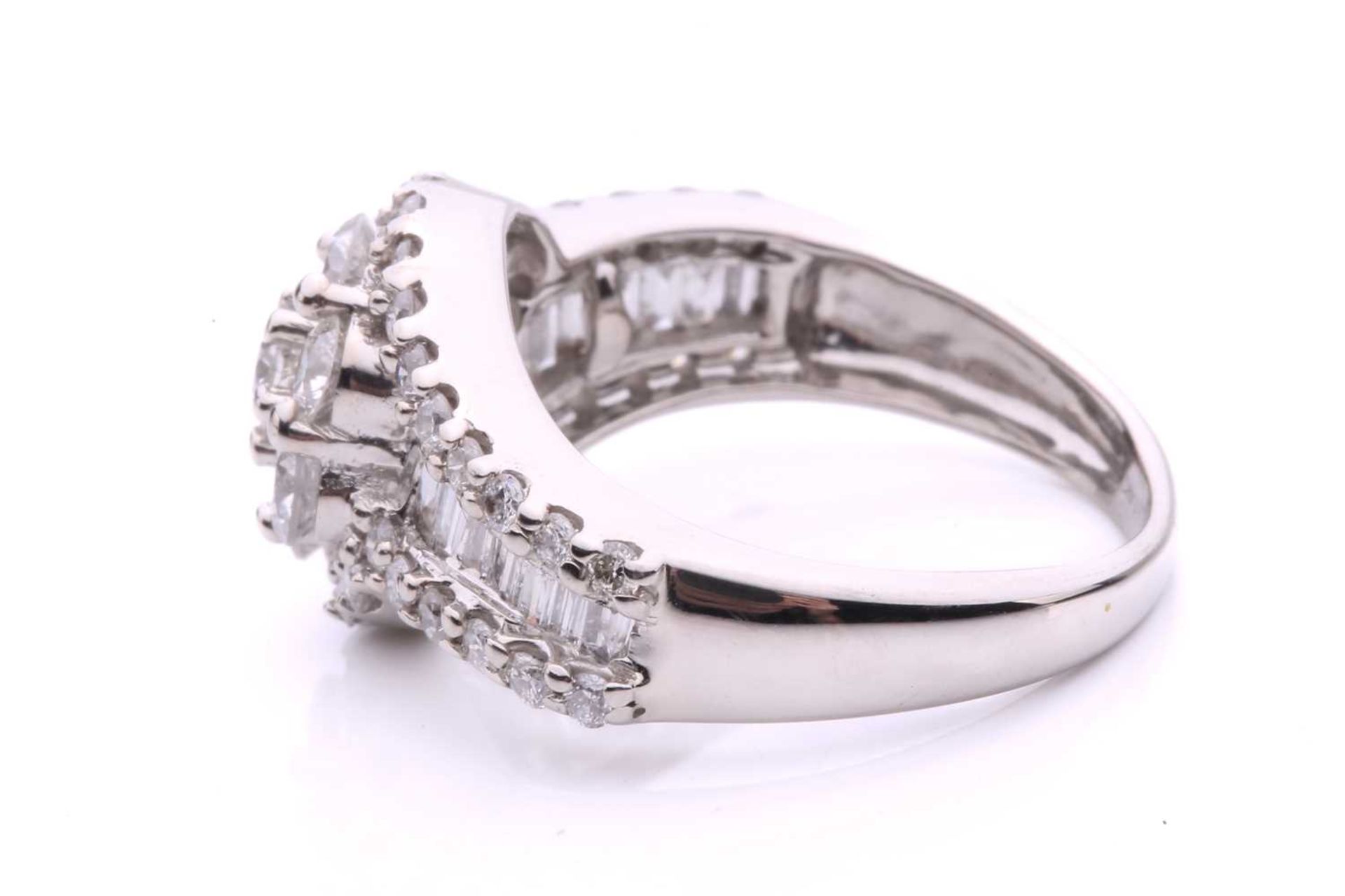 A diamond cluster crossover ring, with seven claw set round brilliant cut diamonds in a daisy - Image 3 of 6