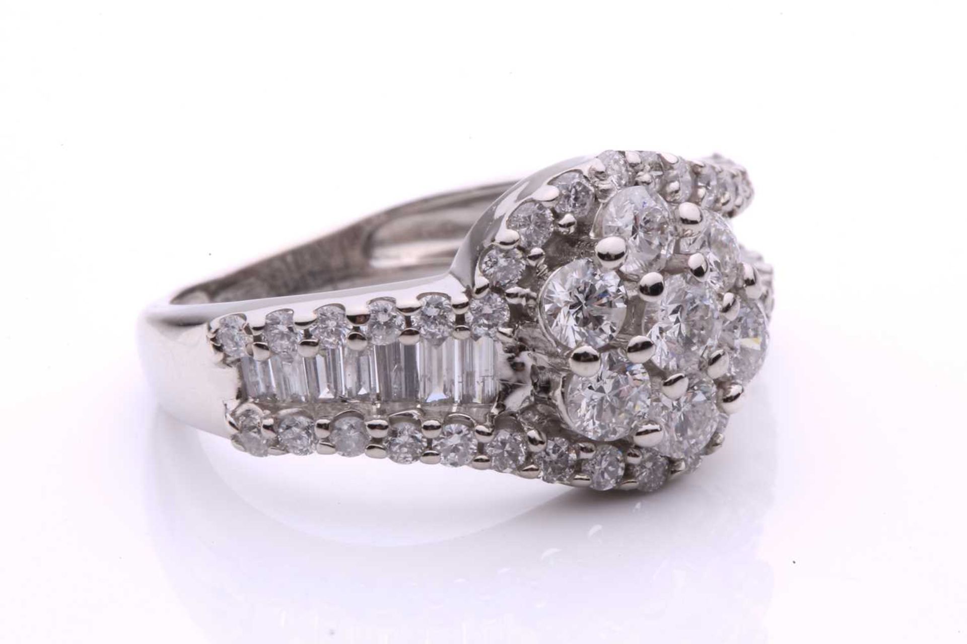 A diamond cluster crossover ring, with seven claw set round brilliant cut diamonds in a daisy - Image 5 of 6