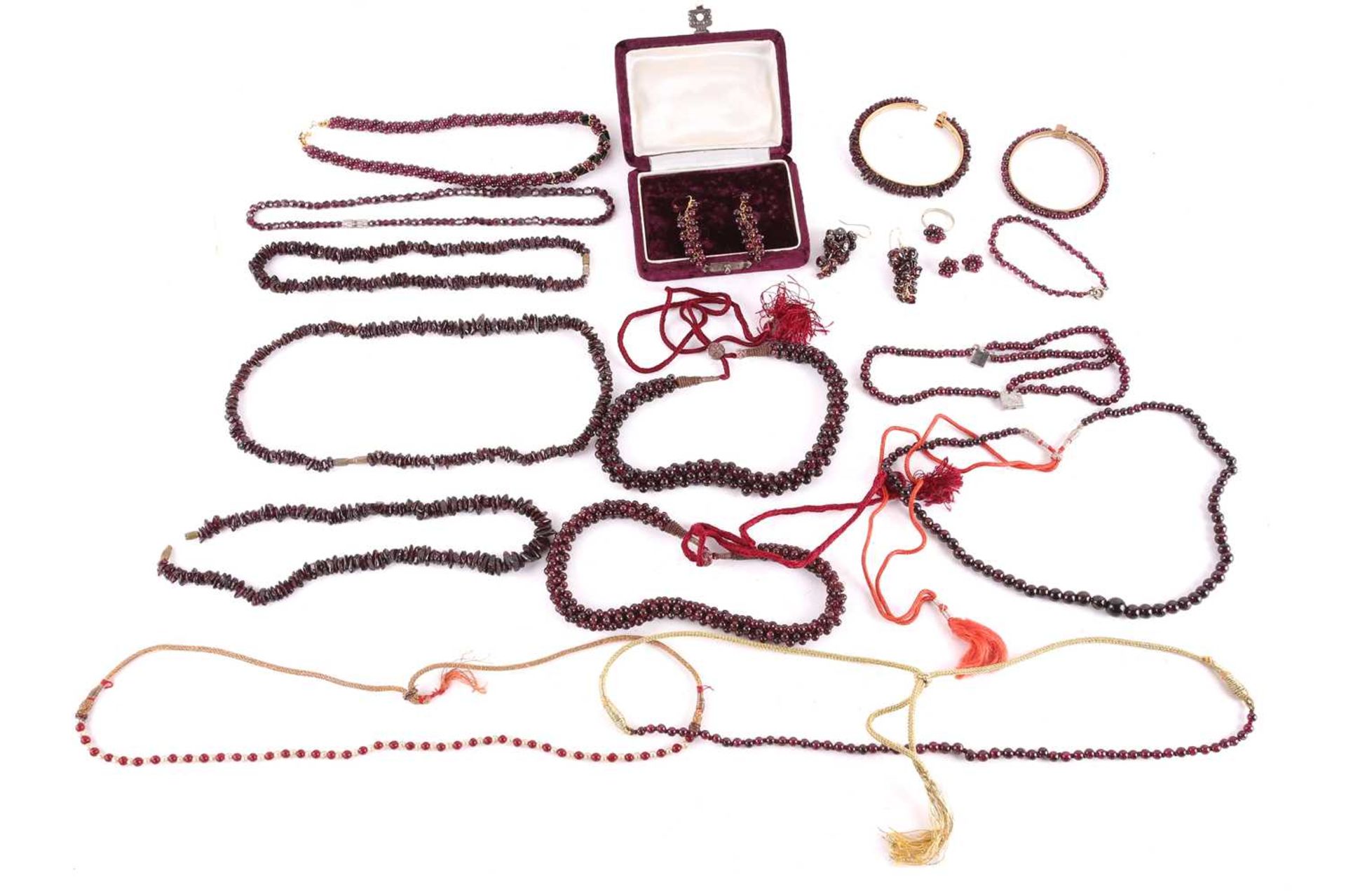 A large collection of garnet beaded jewellery; including four drawstring necklaces with adjustable