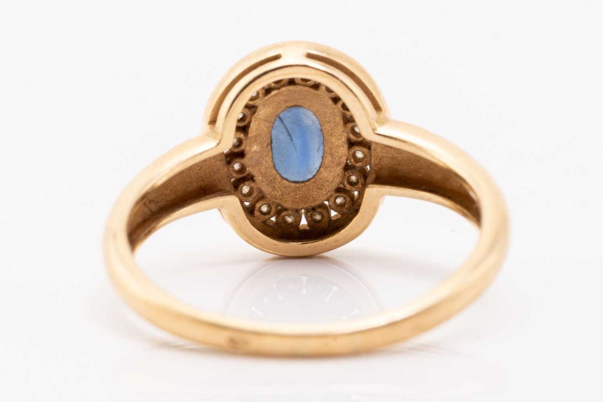 A yellow metal, sapphire and diamond halo ring, centred with an oval-cut sapphire in collet, - Image 4 of 4