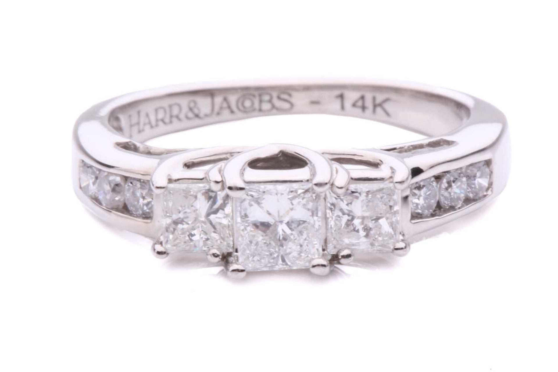 A three-stone princess cut ring with a diamond set shoulder, with three claw set princess cut