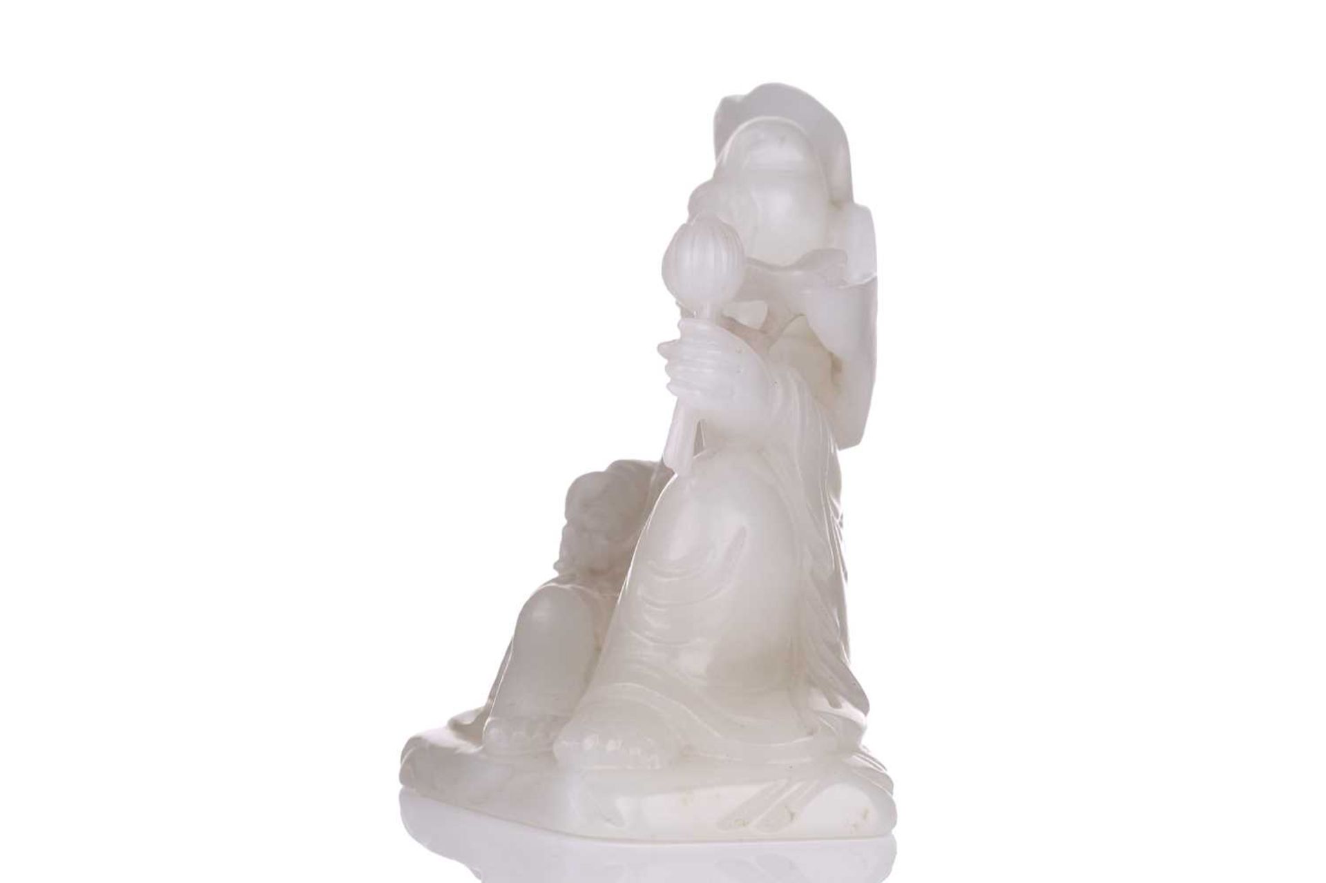 A Chinese white jade figure of Guanyin, seated in a recumbent pose with lotus flower in her left - Image 13 of 14