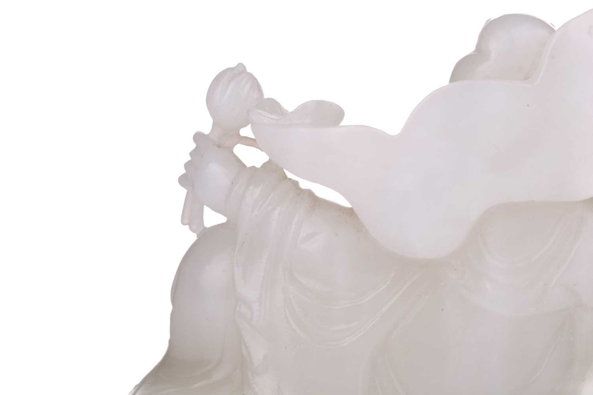 A Chinese white jade figure of Guanyin, seated in a recumbent pose with lotus flower in her left - Bild 9 aus 14