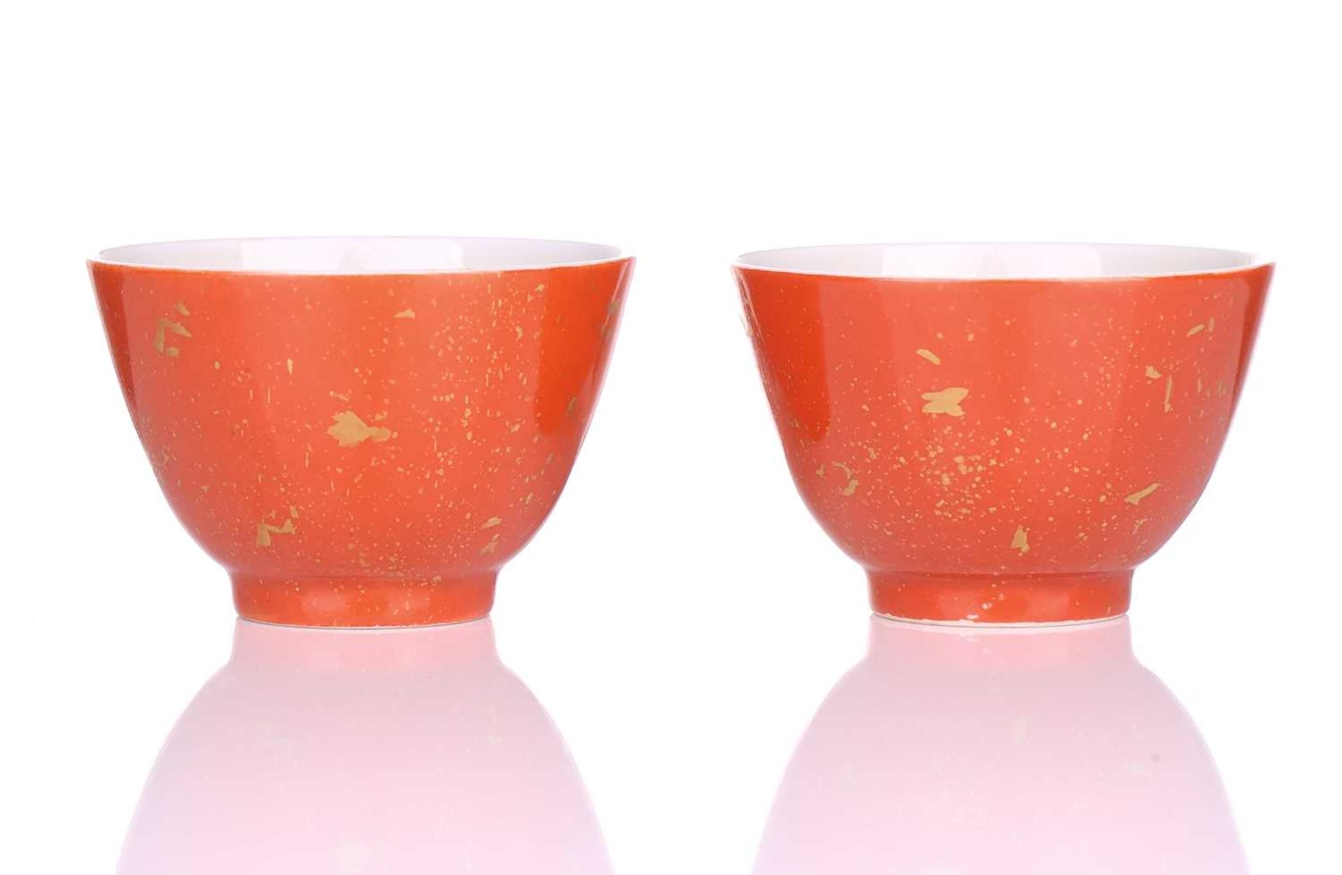 A pair of Chinese porcelain tea bowls, Republic period, with gilt splashes on a coral ground,