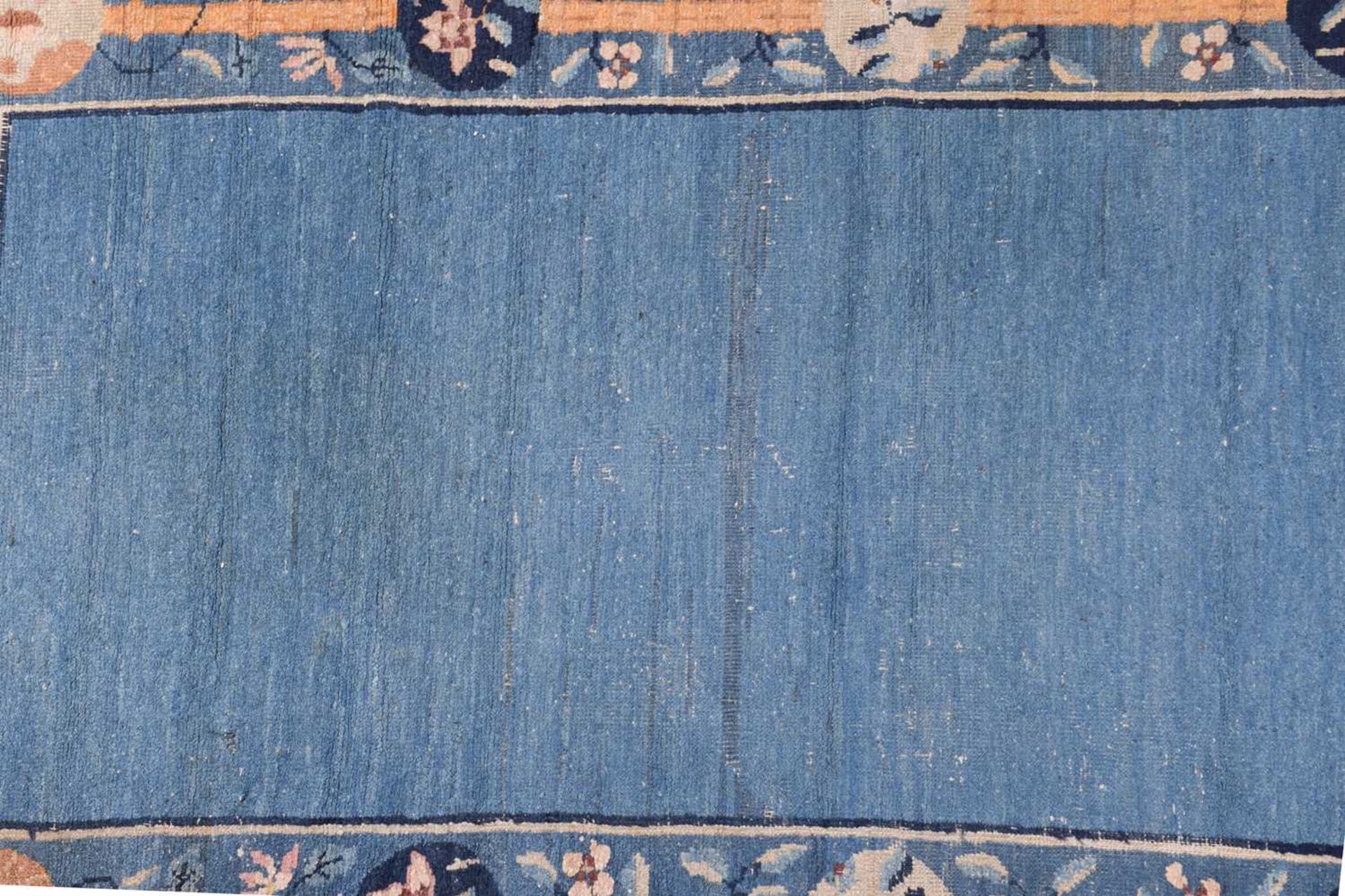 A Chinese Peking blue ground rug, late Qing, within borders of bamboo and butterflies, bearing a - Image 3 of 8